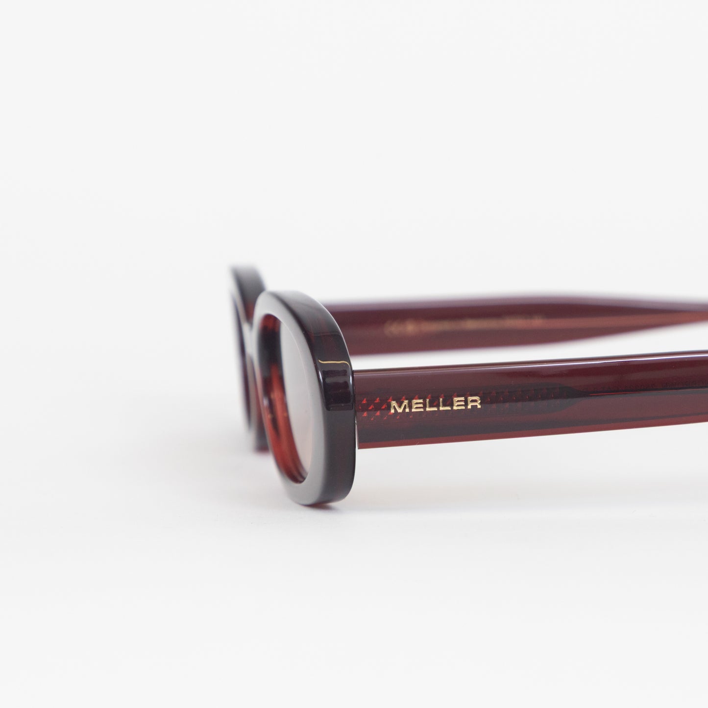Close-up of a pair of sunglasses with 'Meller' branding on a white background