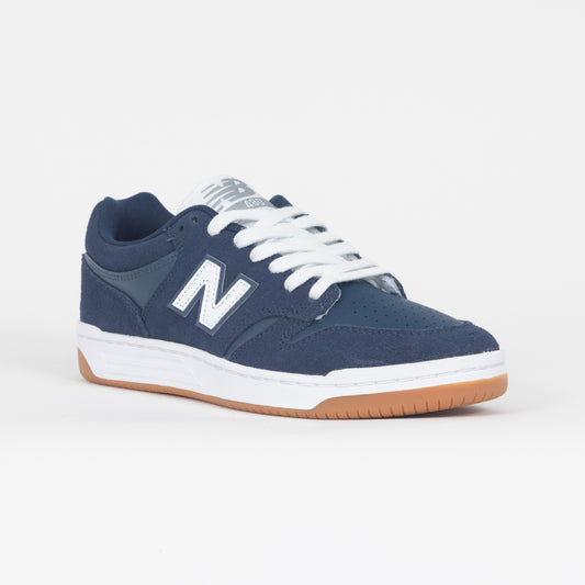 Navy blue new balance trainer with white laces and brown sole on a white background