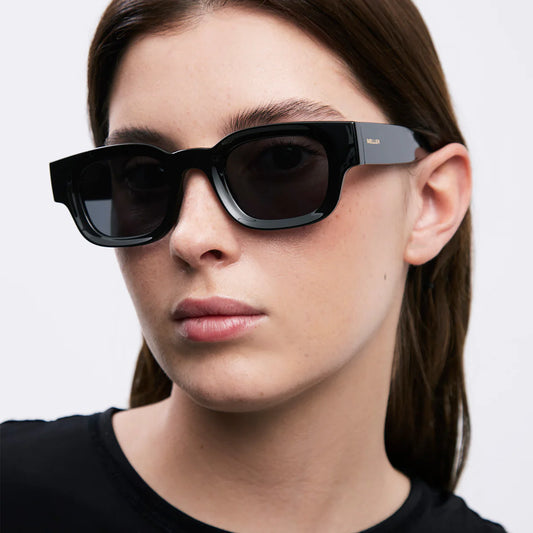 Person wearing meller black sunglasses with a neutral background
