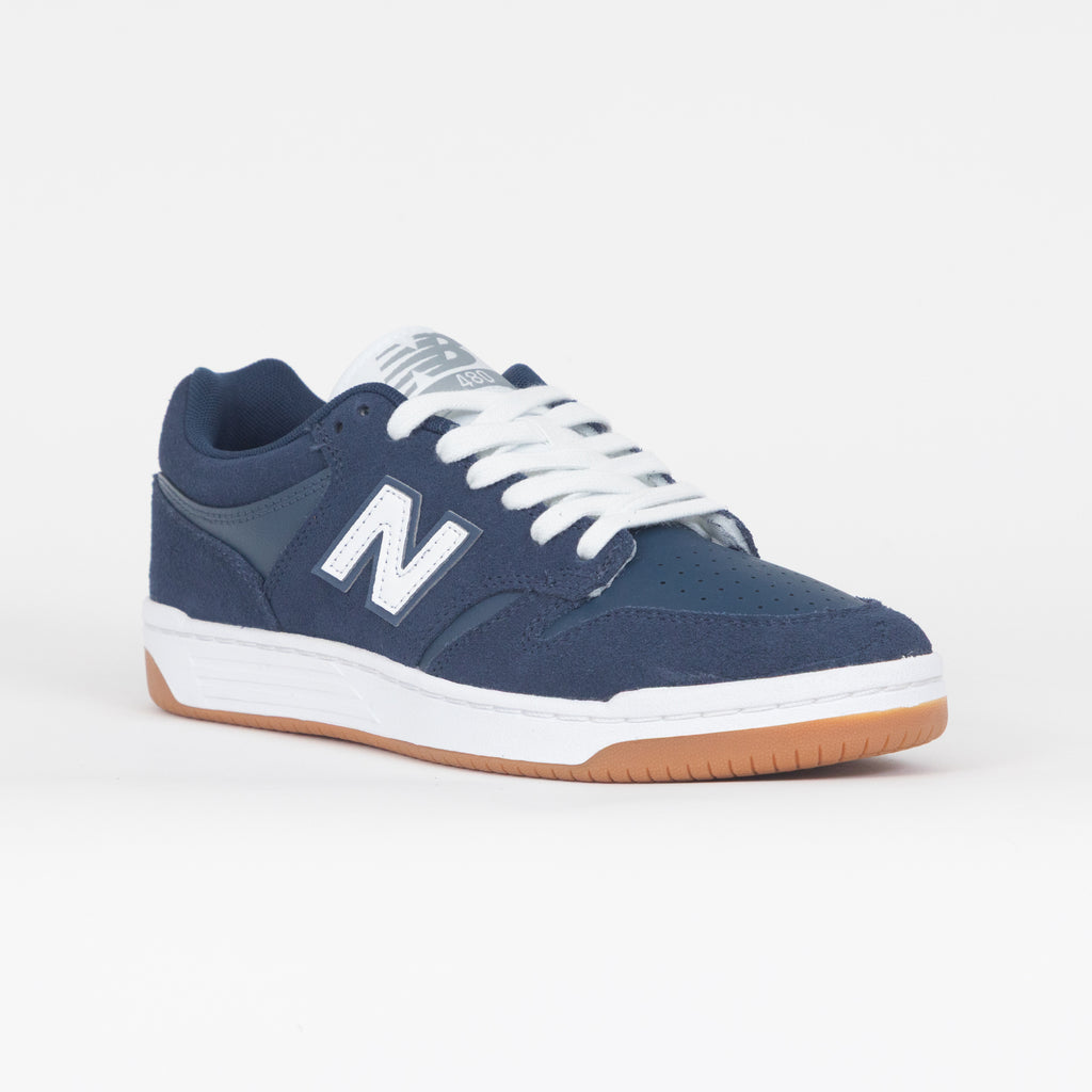 Navy blue new balance trainer with white laces and brown sole on a white background