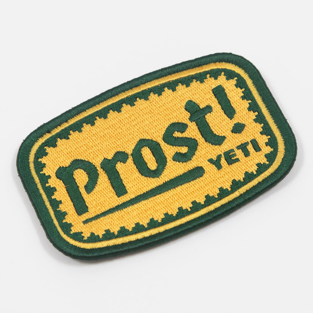 Embroidered patch with 'Prost! YETI' text on a yellow and green background