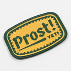 Embroidered patch with 'Prost! YETI' text on a yellow and green background