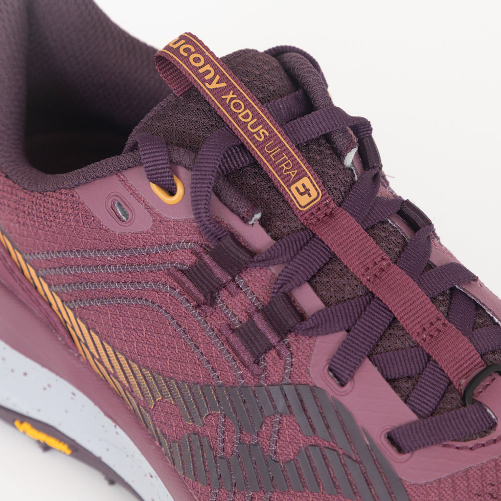 Close-up of a purple running shoe with laces and saucony brand label.