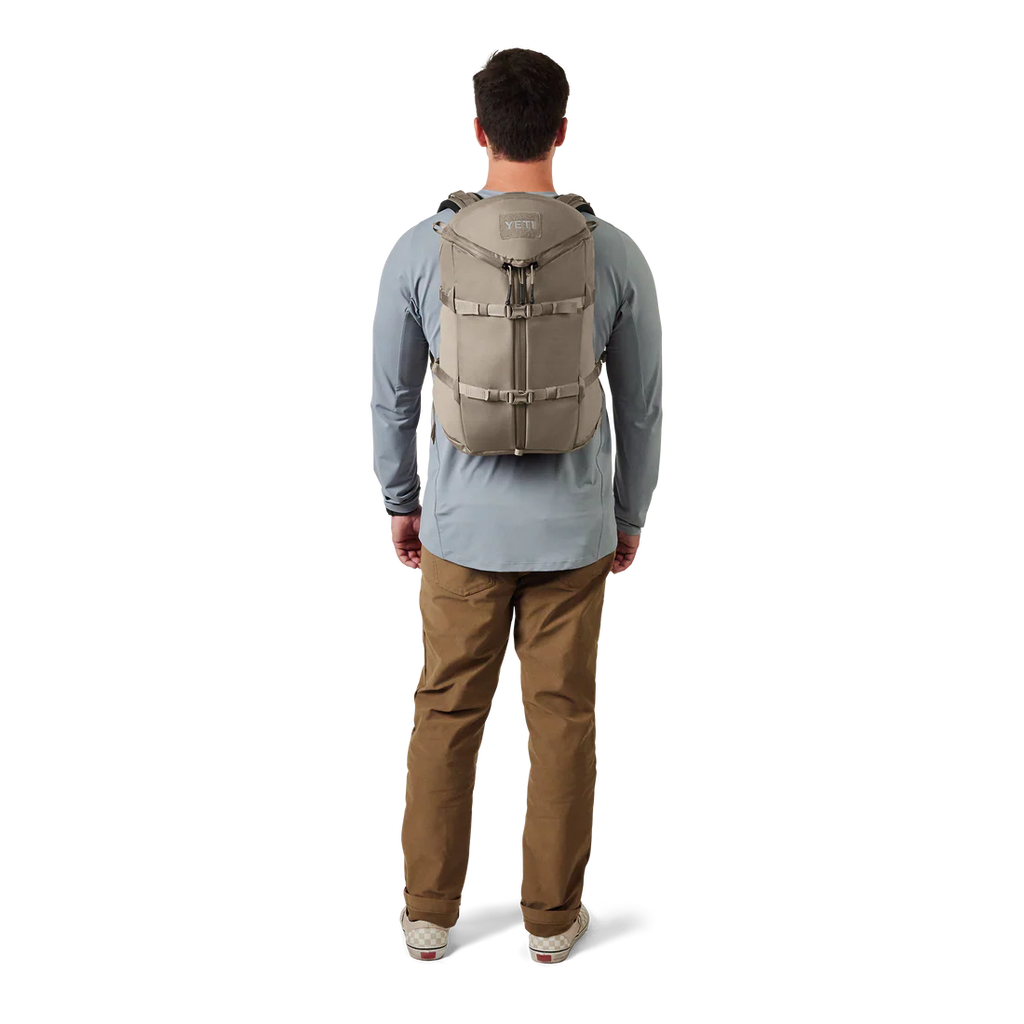 Man wearing YETI beige backpack 
