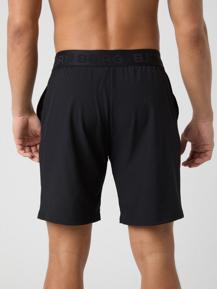 Black athletic shorts with a brand logo on a plain background