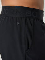 Black athletic shorts with a brand logo on the waistband against a neutral background