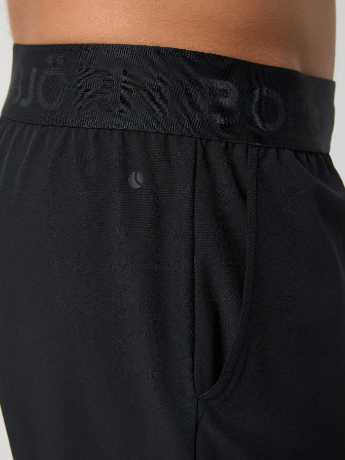 Black athletic shorts with a brand logo on the waistband against a neutral background